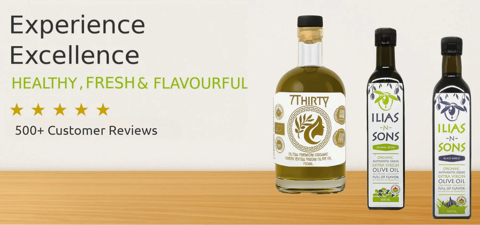 Three bottles of Ilias and Sons High Phenolic, Organic Greek Extra Virgin Olive Oil and Organic Greek Extra Virgin Olive Oil infused with Black Garlic in olive oil on a wooden surface with branding and product details.