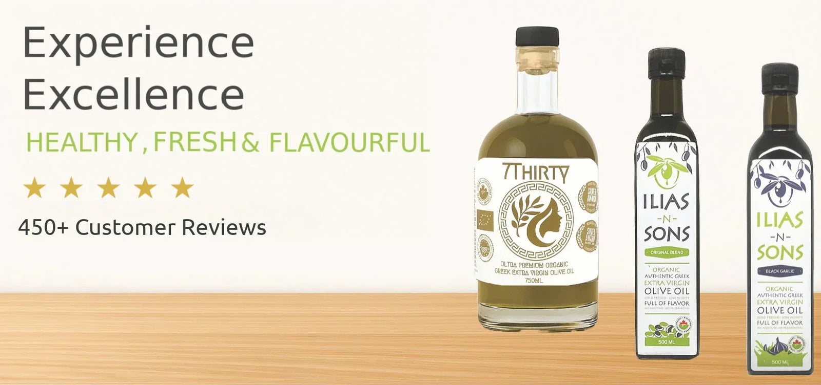 Three bottles of Ilias and Sons High Phenolic, Organic Greek Extra Virgin Olive Oil and Organic Greek Extra Virgin Olive Oil infused with Black Garlic in olive oil on a wooden surface with branding and product details.